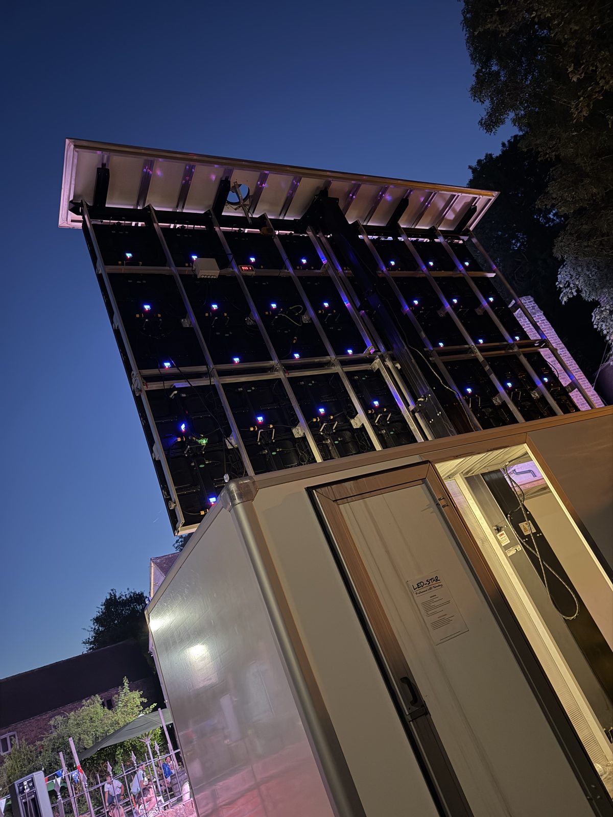 The trailer-mounted LED screen raised and running at dusk